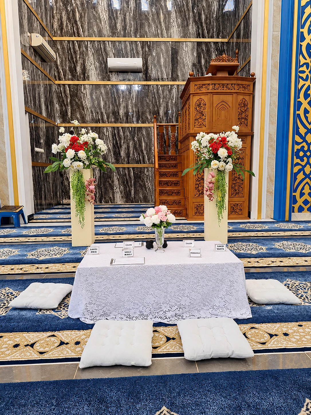 Meja akad nikah berbalut kain putih di atas karpet biru Ruang Utama