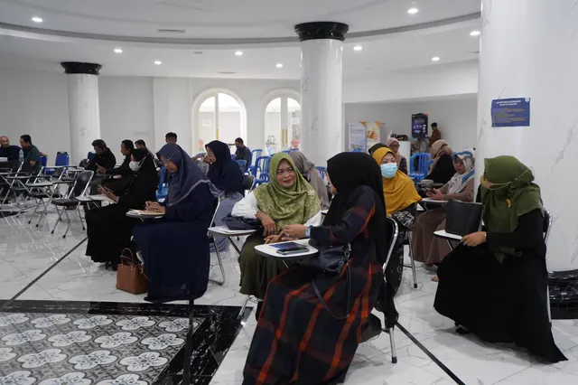 Peserta seminar UMKM duduk mencatat materi di Aula Serbaguna